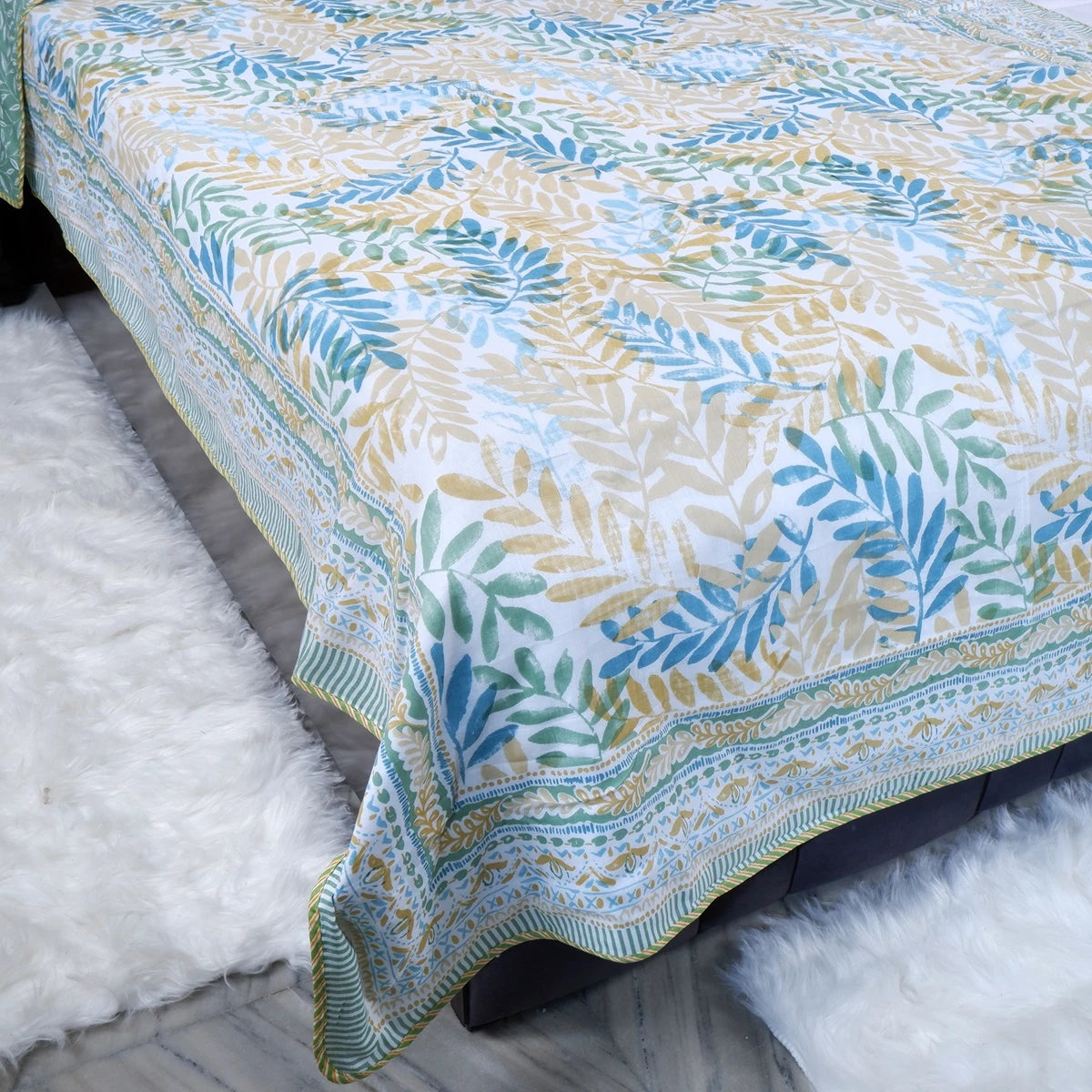 Lightweight 100 percent mulmul cotton blanket featuring a floral design in green and blue tones