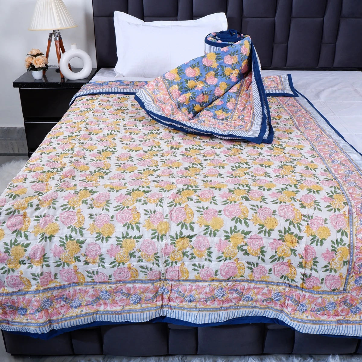 The Jaipuri 100% pure cotton single bed quilt with floral design in vibrant colors on a bed