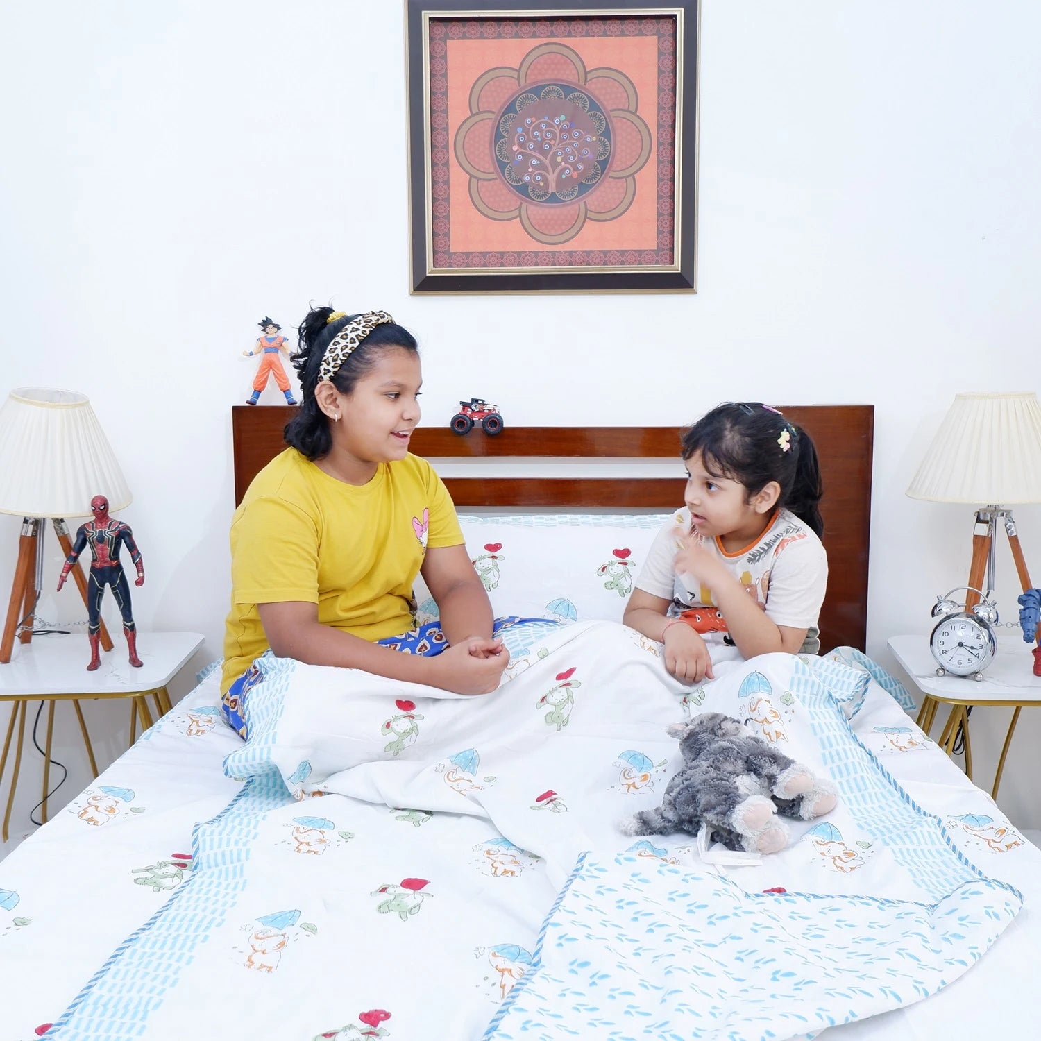Two children chatting under a hand block print kids dohar on a cozy bed