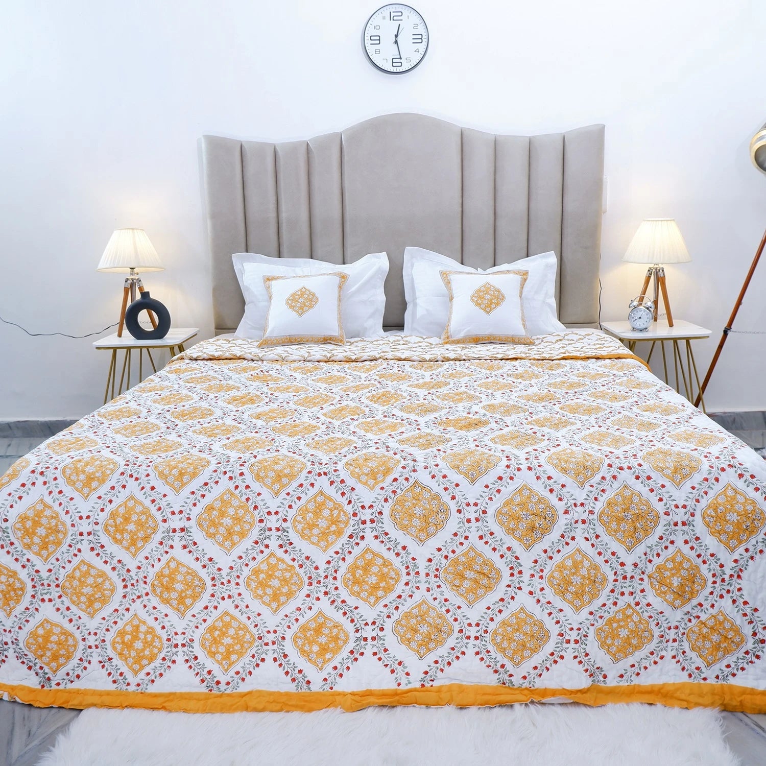 The Jaipuri block print cotton quilt for double bed in vibrant yellow and white patterns, enhancing bedroom decor.