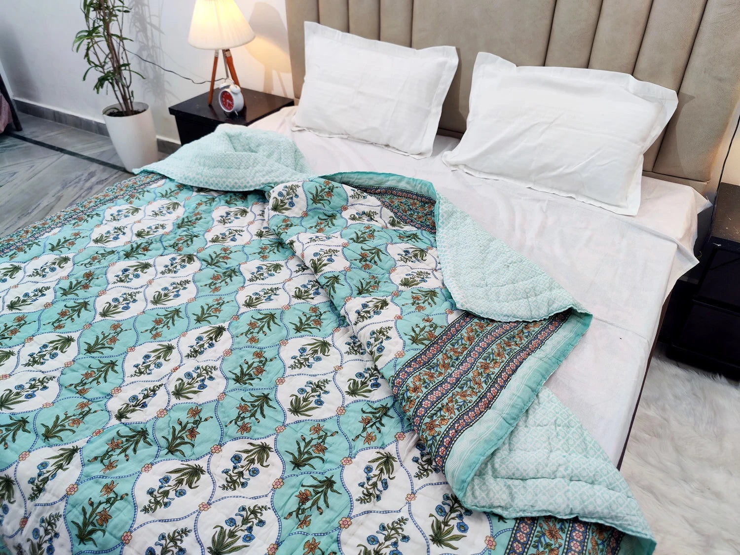 The Jaipuri cotton quilt for double bed block print in light blue with floral design on a bed