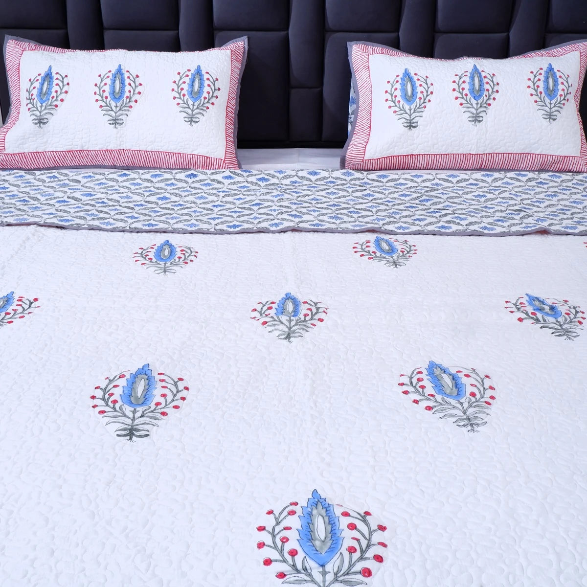 Hand block print cotton bedcover by The Jaipuri featuring floral designs in blue and red colors