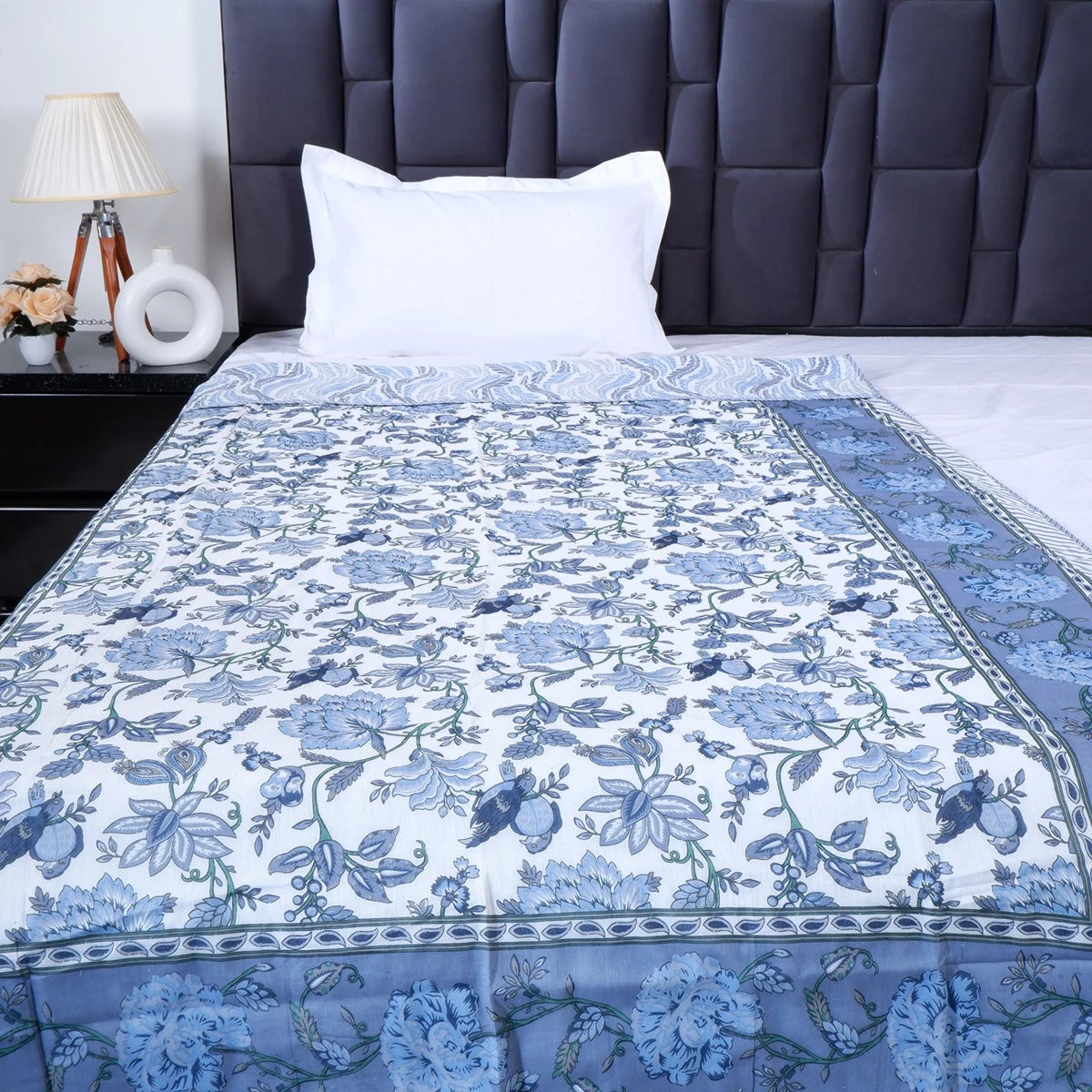Hand block print mulmul cotton dohar in blue floral design on a neatly made bed