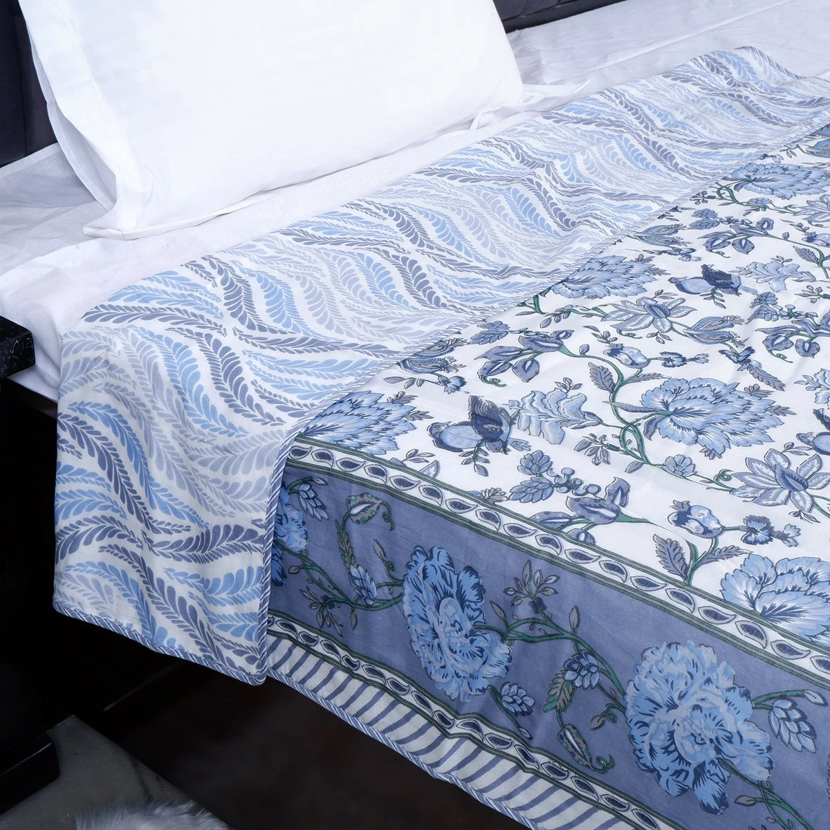 Hand block print mulmul cotton dohar with elegant blue floral patterns on a soft bed