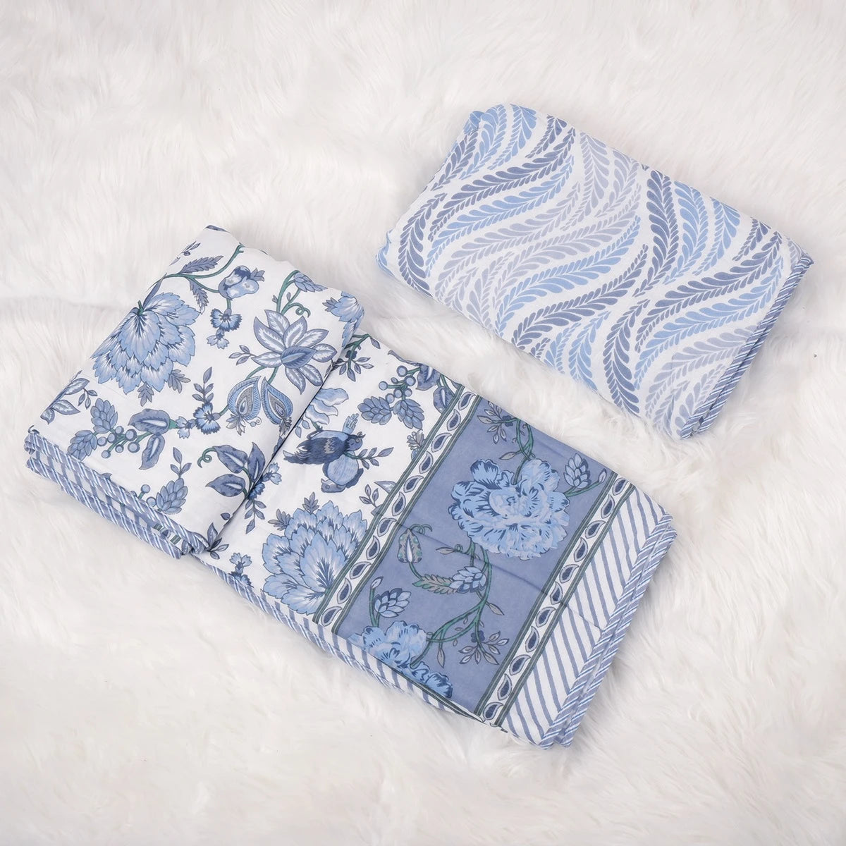 Two beautiful hand block print mulmul cotton dohars in blue floral designs, perfect for cozy bedding.