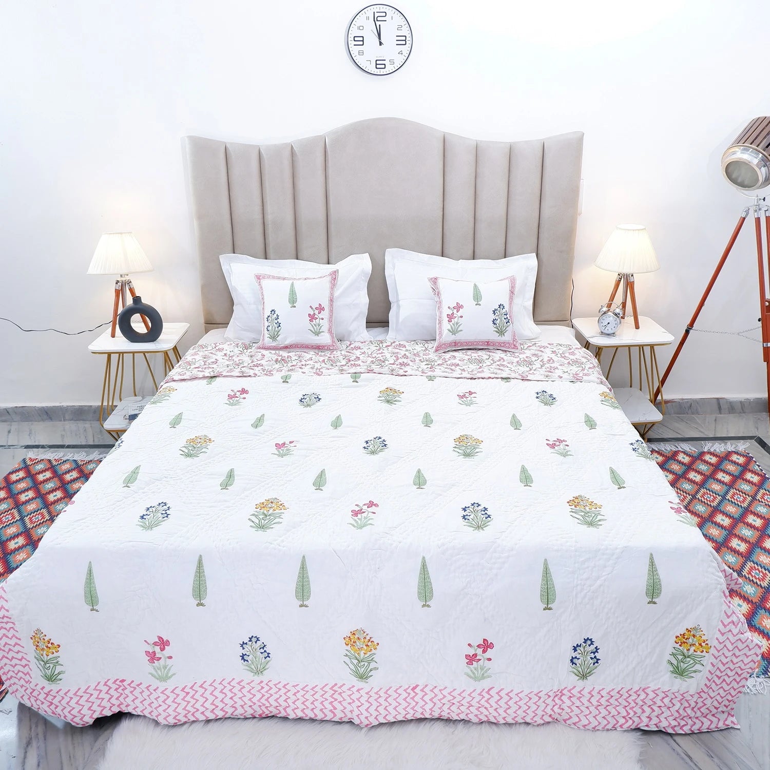 Jaipuri block print quilt set featuring floral patterns and soft pastel colors on a bed