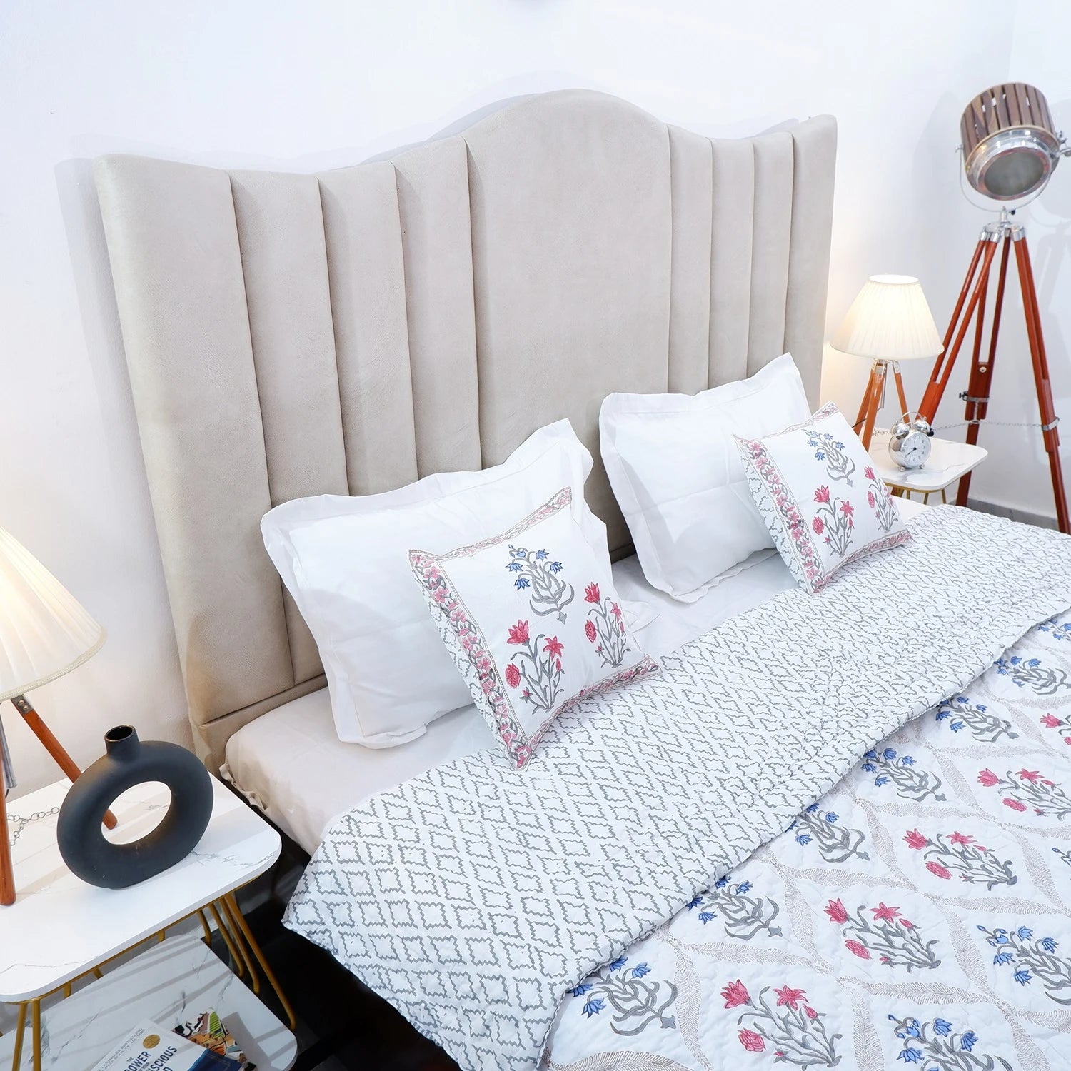 Jaipuri block print quilts displayed on a bed with decorative pillows and stylish headboard