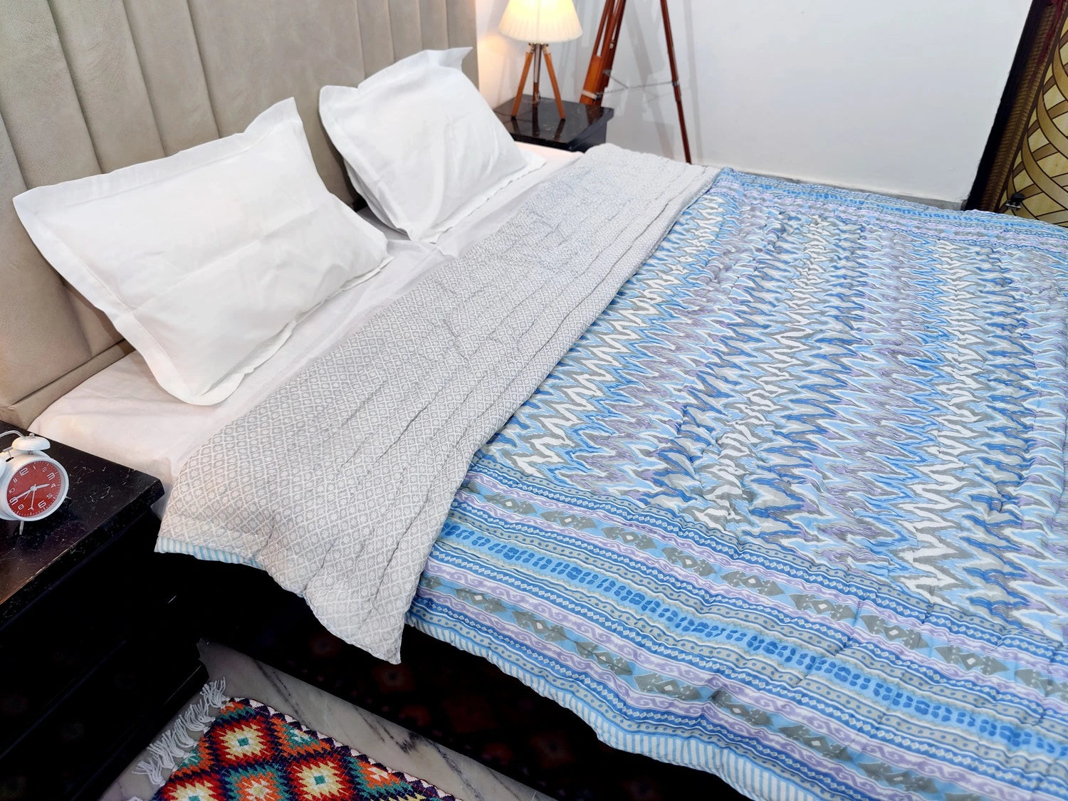 Jaipuri cotton quilt double bed in vibrant colors, elegantly spread on a stylish bed with white linens.