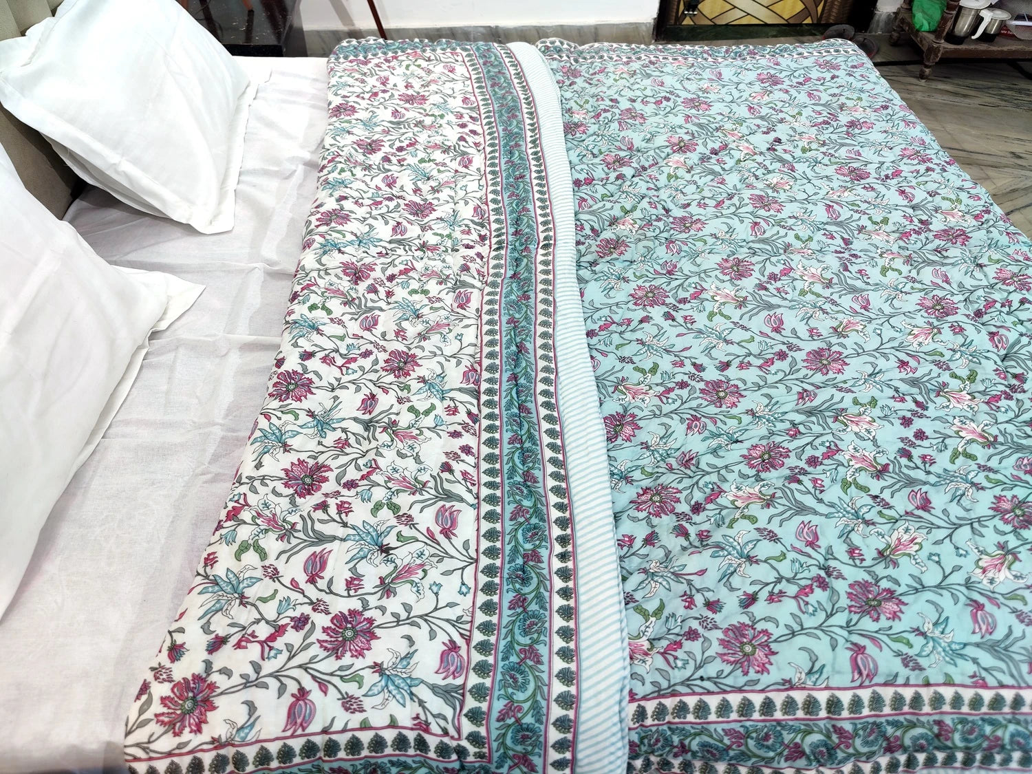 Jaipuri cotton quilt double bed with colorful floral patterns and intricate detailing on a white bed