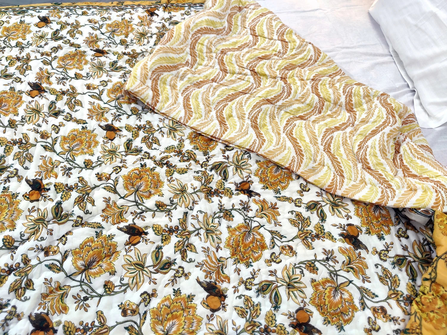 Jaipuri cotton quilt double bed featuring vibrant floral patterns and a textured yellow design