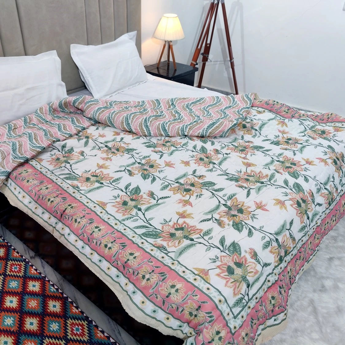 Jaipuri cotton quilt double bed with floral design and vibrant colors spread over a neatly made bed