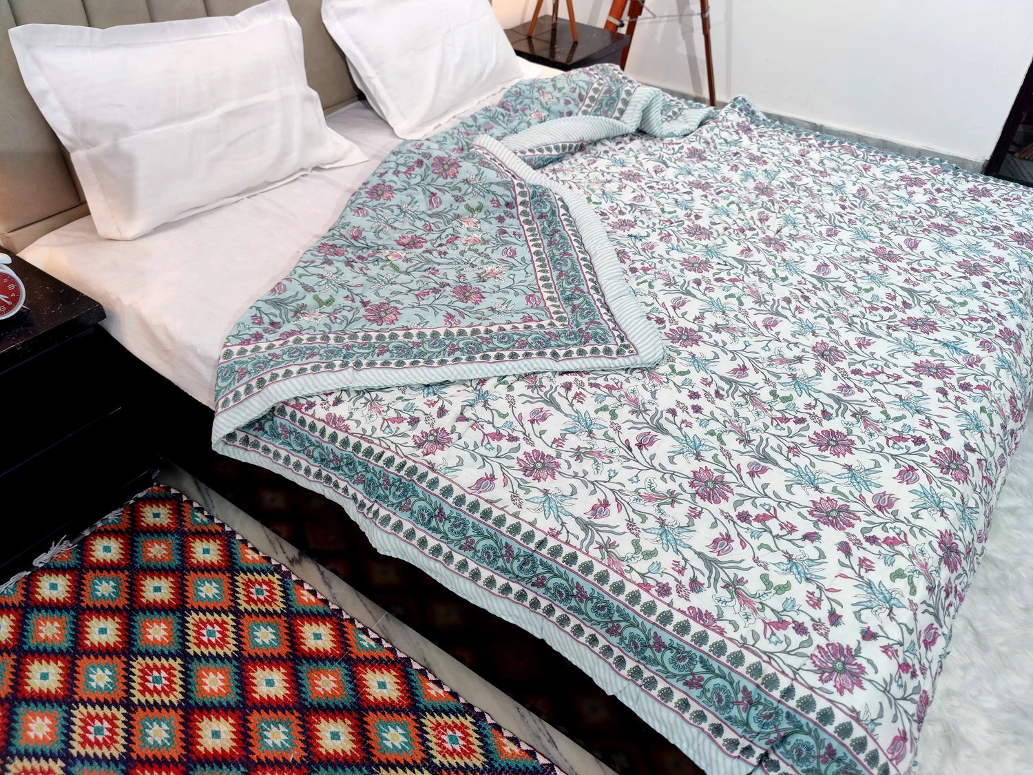 Jaipuri cotton quilt double bed featuring intricate floral patterns in soft colors on a styled bed