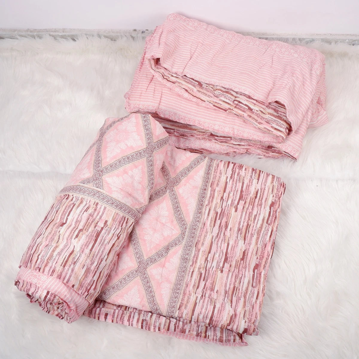 Jaipuri cotton quilt single bed in pink with intricate patterns and fabric texture laid out