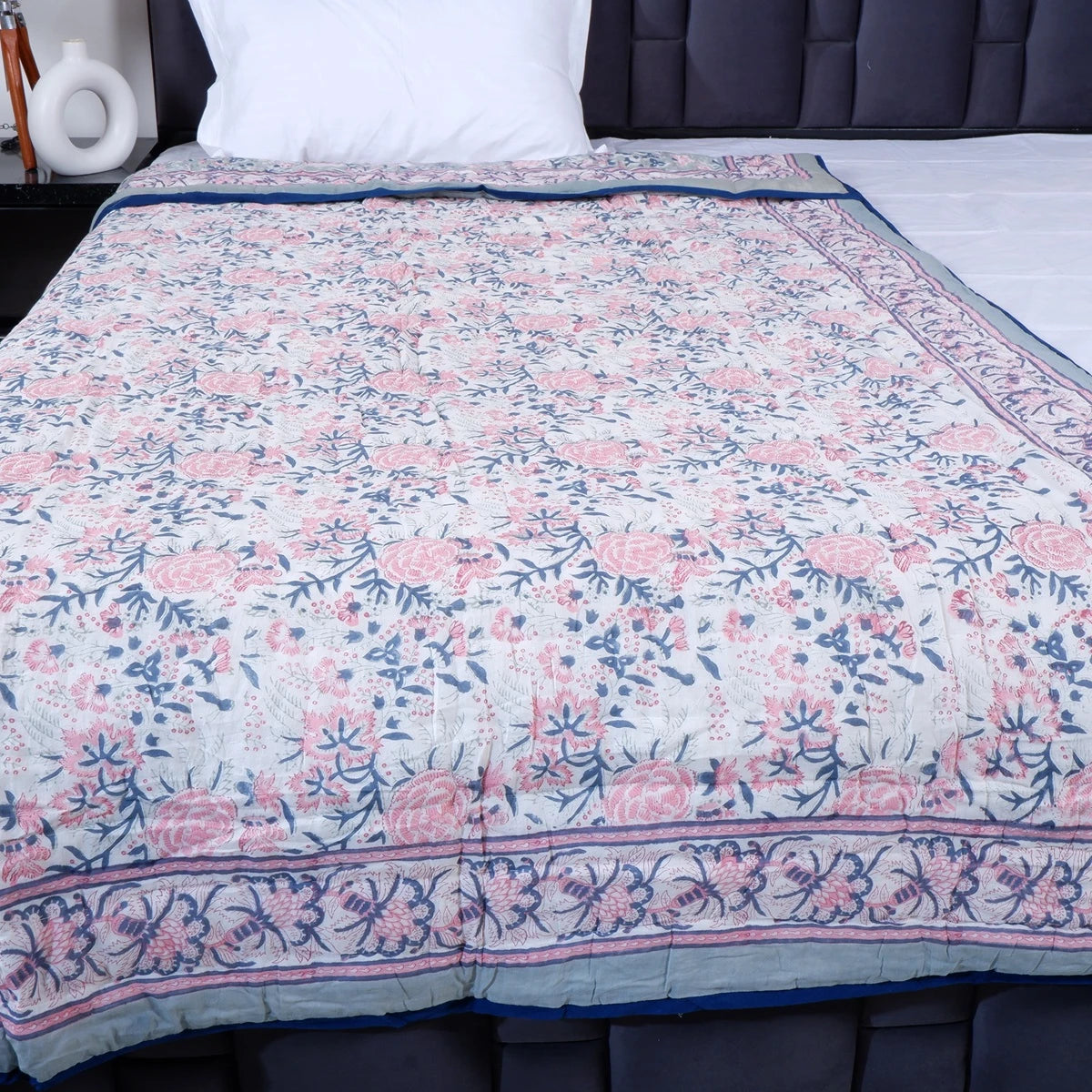 Jaipuri cotton quilts single bed with floral print design in soft pastel colors on a bed