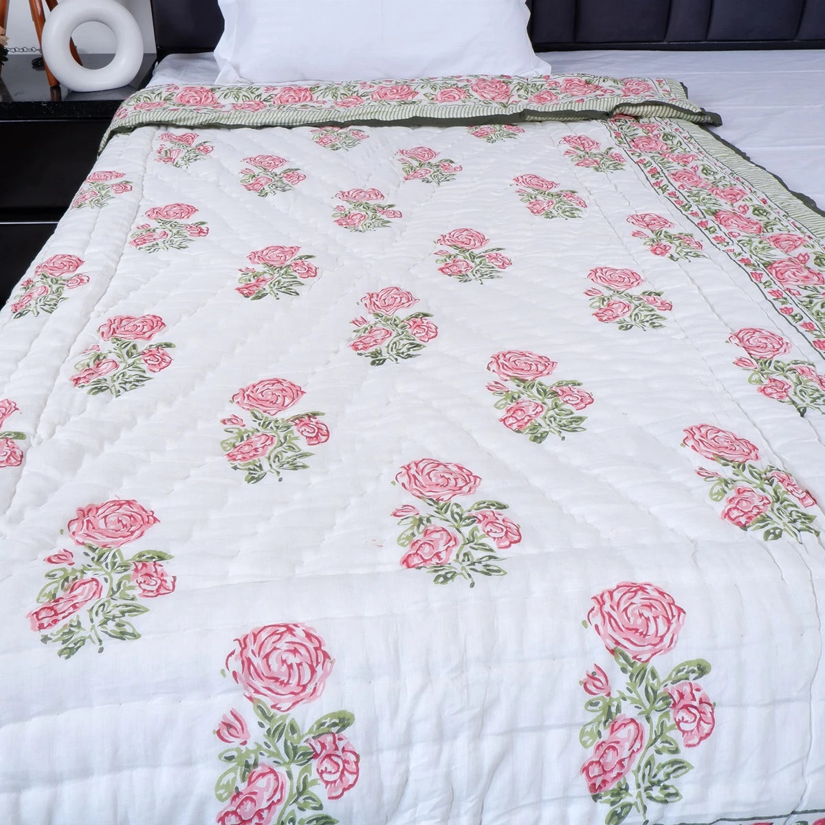 Jaipuri quilt single bed featuring floral print in pink and green against a white background