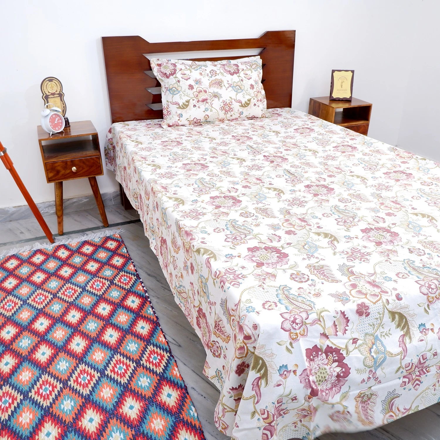 The Jaipuri pure cotton bed sheet in floral design on a neatly made bed with wooden furniture