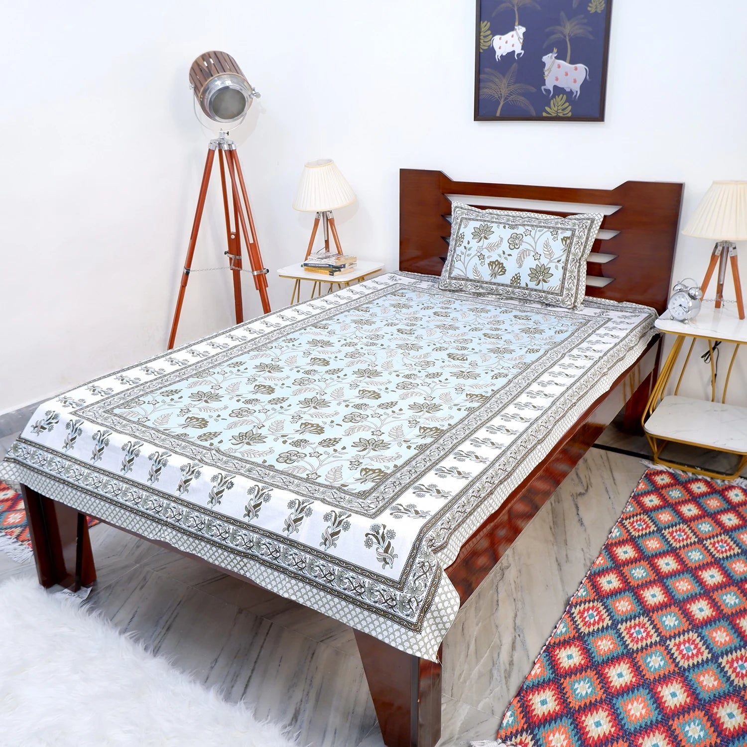 The Jaipuri pure cotton bed sheet with intricate floral patterns on a cozy bed setup