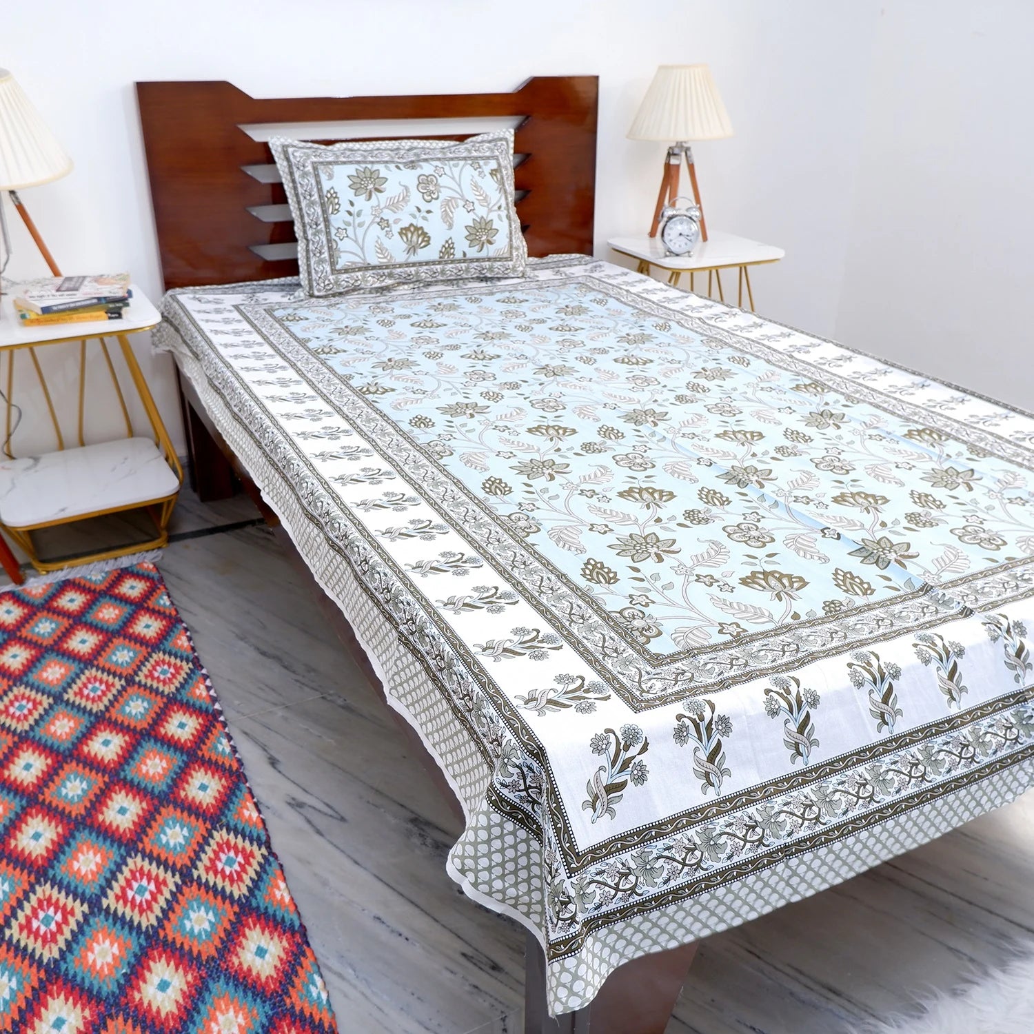 The Jaipuri pure cotton bed sheet with intricate floral design and contrasting border on a stylish bed